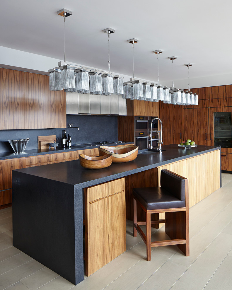 Esempio di un cucina con isola centrale design con lavello sottopiano, ante lisce, ante in legno bruno, paraspruzzi nero e parquet chiaro