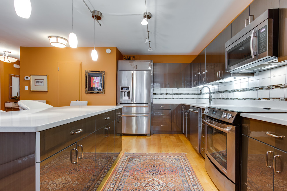 This is an example of a medium sized contemporary l-shaped kitchen in DC Metro with a submerged sink, engineered stone countertops, stainless steel appliances, medium hardwood flooring and an island.