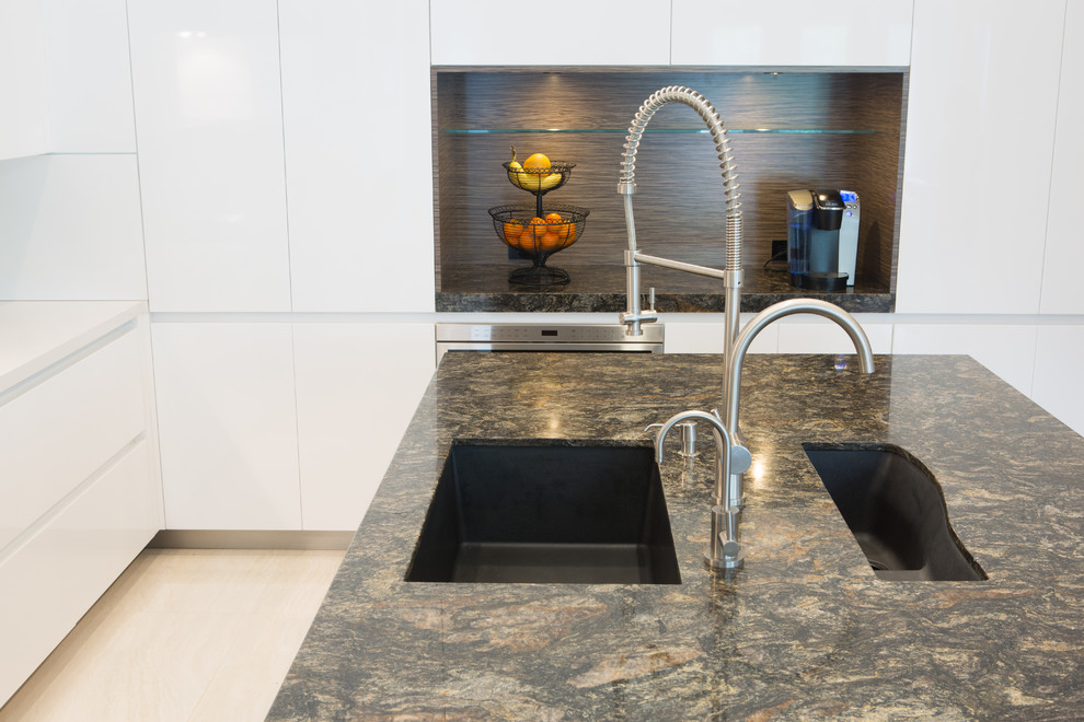 Large contemporary u-shaped open plan kitchen in Miami with a submerged sink, flat-panel cabinets, white cabinets, granite worktops, white splashback, stone slab splashback, stainless steel appliances, porcelain flooring and an island.