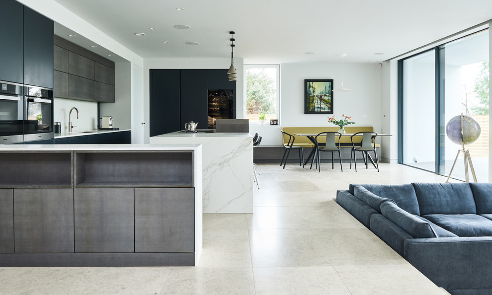 Inspiration for a contemporary u-shaped open plan kitchen in Devon with flat-panel cabinets, grey cabinets, limestone flooring, an island, grey floors, a submerged sink, white splashback and white worktops.