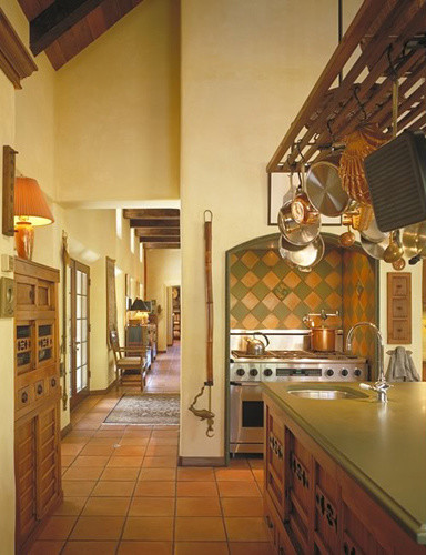 Bild på ett avskilt, stort amerikanskt grön grönt u-kök, med en undermonterad diskho, luckor med lamellpanel, skåp i mellenmörkt trä, bänkskiva i koppar, orange stänkskydd, stänkskydd i keramik, rostfria vitvaror, travertin golv och en köksö