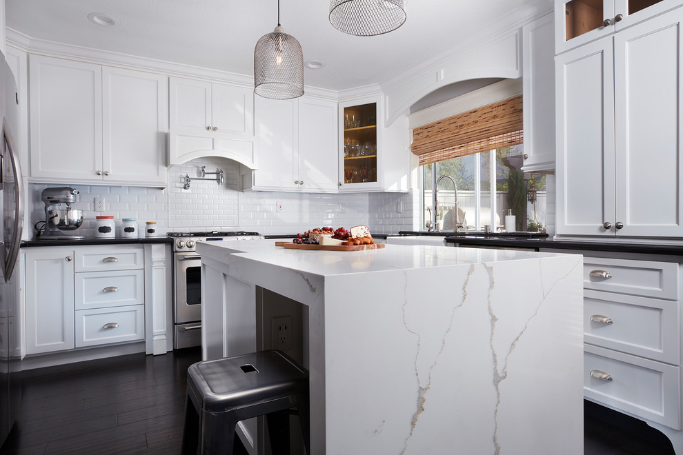 Modern inredning av ett mellanstort kök, med en rustik diskho, skåp i shakerstil, vita skåp, bänkskiva i kvarts, vitt stänkskydd, stänkskydd i keramik, rostfria vitvaror, mörkt trägolv, en köksö och brunt golv