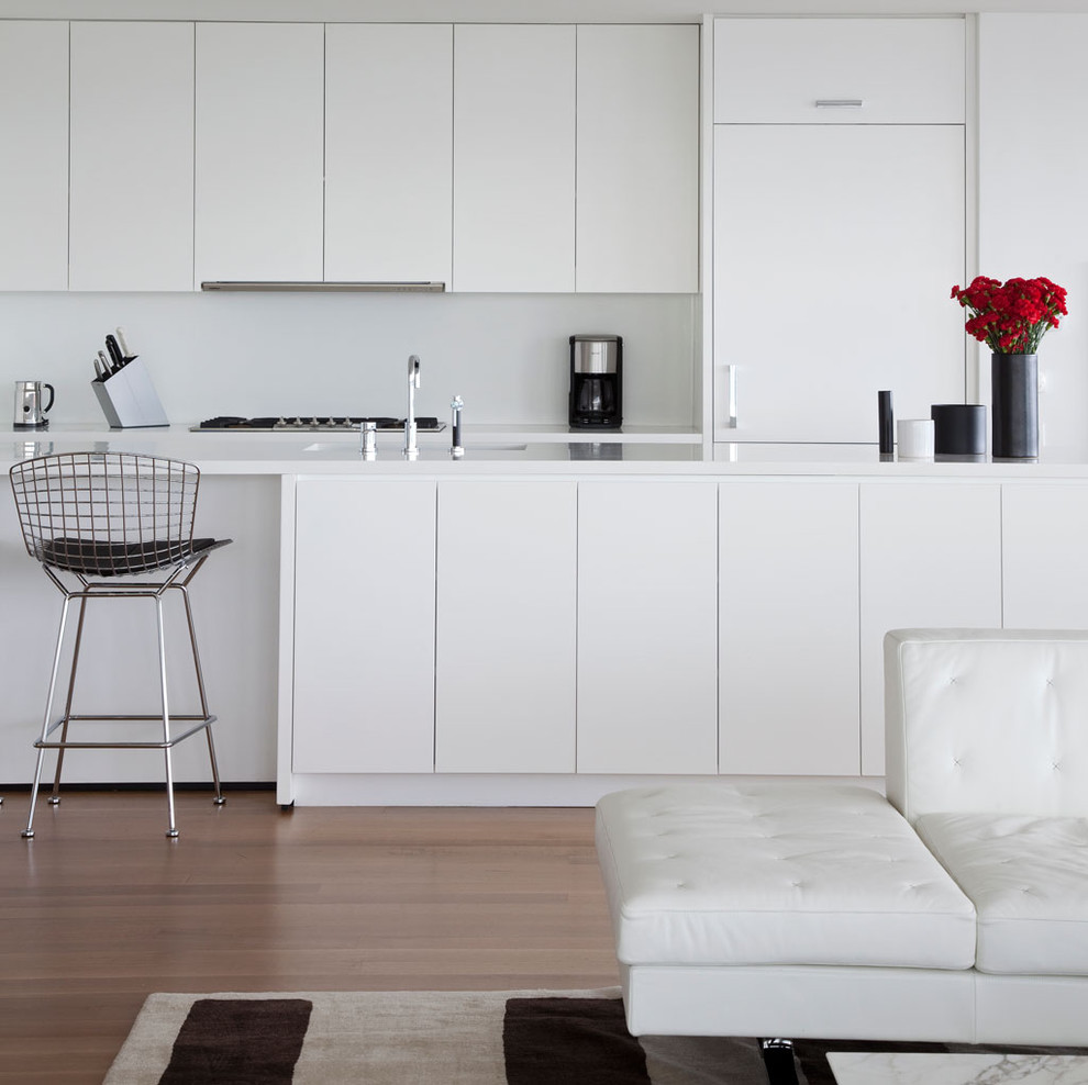 Immagine di una cucina contemporanea con ante lisce, ante bianche, paraspruzzi bianco e elettrodomestici da incasso
