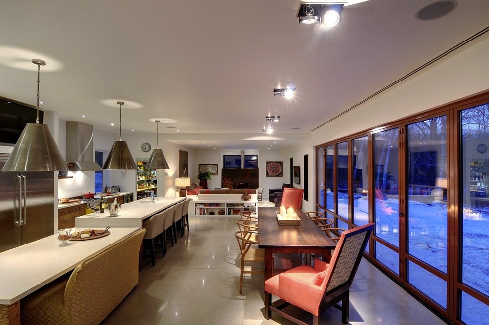 Идея дизайна: параллельная кухня-гостиная в современном стиле с плоскими фасадами, фасадами цвета дерева среднего тона, белым фартуком и техникой из нержавеющей стали