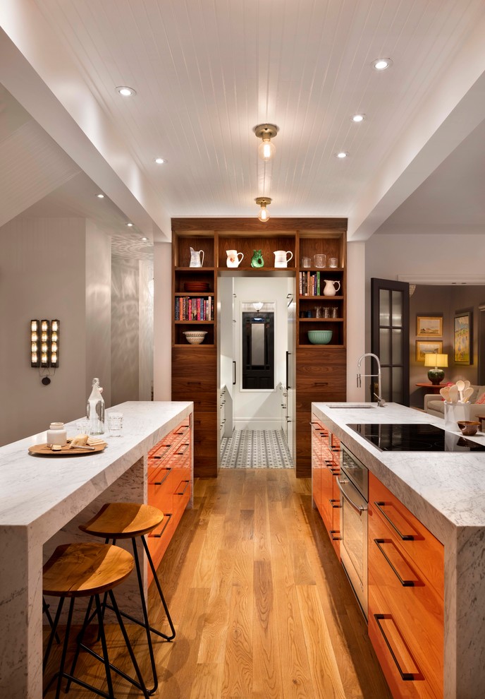 Example of a mid-sized trendy galley medium tone wood floor open concept kitchen design in Denver with two islands, an undermount sink, flat-panel cabinets, medium tone wood cabinets, marble countertops and stainless steel appliances