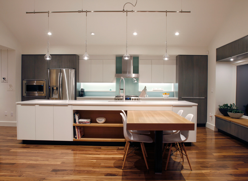 Example of a mid-sized trendy galley dark wood floor eat-in kitchen design in Denver with flat-panel cabinets, gray cabinets, quartz countertops, blue backsplash, glass sheet backsplash, stainless steel appliances and an island