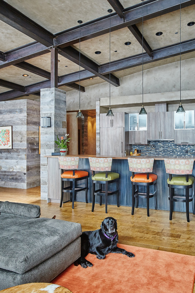 Exempel på ett modernt kök med öppen planlösning, med släta luckor, grå skåp, blått stänkskydd, stänkskydd i stickkakel, integrerade vitvaror, mellanmörkt trägolv och en köksö
