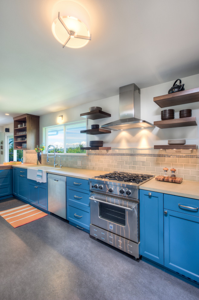 Design ideas for a large contemporary u-shaped kitchen/diner in Seattle with a belfast sink, shaker cabinets, blue cabinets, wood worktops, grey splashback, metro tiled splashback, stainless steel appliances, concrete flooring and a breakfast bar.