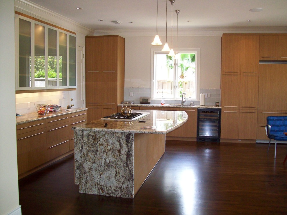 Large trendy u-shaped dark wood floor kitchen photo in Houston with light wood cabinets, white backsplash, stainless steel appliances and an island