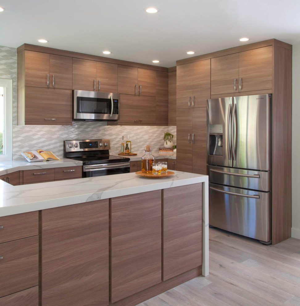 Photo of a medium sized contemporary u-shaped kitchen/diner in San Diego with a submerged sink, white splashback, stainless steel appliances, white worktops, flat-panel cabinets, medium wood cabinets, engineered stone countertops, porcelain splashback, vinyl flooring, no island and grey floors.