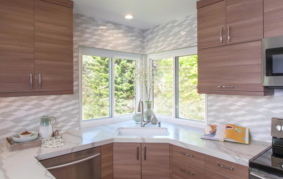 Foto på ett mellanstort funkis vit kök, med en undermonterad diskho, vitt stänkskydd, rostfria vitvaror, släta luckor, skåp i mellenmörkt trä, bänkskiva i kvarts, stänkskydd i porslinskakel, vinylgolv och grått golv