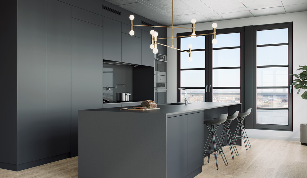 Photo of a medium sized contemporary galley kitchen/diner in Montreal with a submerged sink, flat-panel cabinets, grey cabinets, glass sheet splashback, light hardwood flooring and an island.