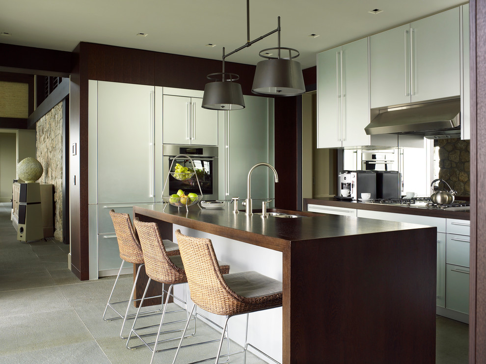 Zweizeilige Moderne Küche mit Doppelwaschbecken, flächenbündigen Schrankfronten, Arbeitsplatte aus Holz, Küchengeräten aus Edelstahl und Kücheninsel in Sonstige