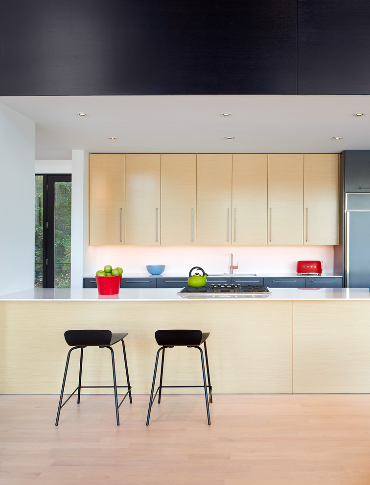 Immagine di una cucina design con ante lisce, ante in legno chiaro, paraspruzzi bianco e parquet chiaro