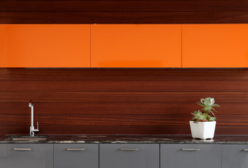 Photo of a contemporary kitchen in Los Angeles with a submerged sink, flat-panel cabinets and orange cabinets.
