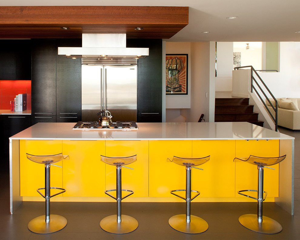 Moderne Küche mit flächenbündigen Schrankfronten, gelben Schränken, Küchenrückwand in Rot und Küchengeräten aus Edelstahl in Los Angeles