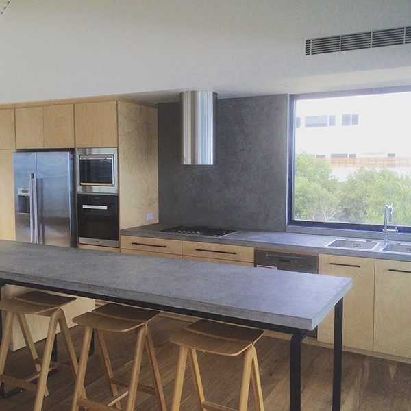 Photo of a medium sized contemporary single-wall kitchen in Adelaide with a double-bowl sink, flat-panel cabinets, light wood cabinets, concrete worktops, grey splashback, stone slab splashback, stainless steel appliances, light hardwood flooring and an island.