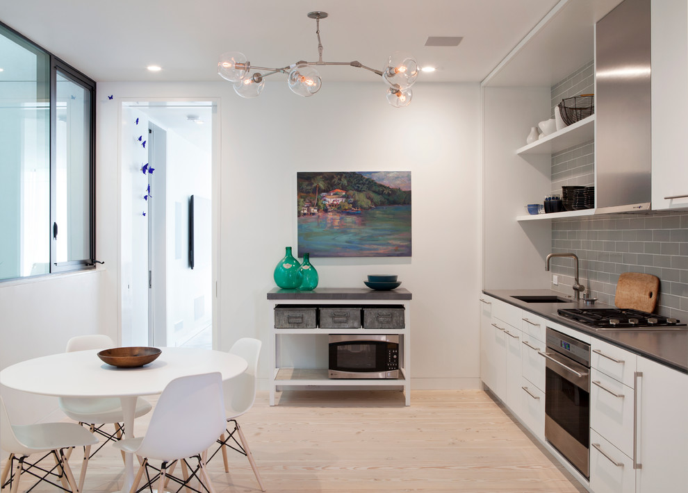 Photo of a contemporary kitchen/diner in San Francisco with open cabinets, white cabinets, grey splashback, metro tiled splashback and stainless steel appliances.