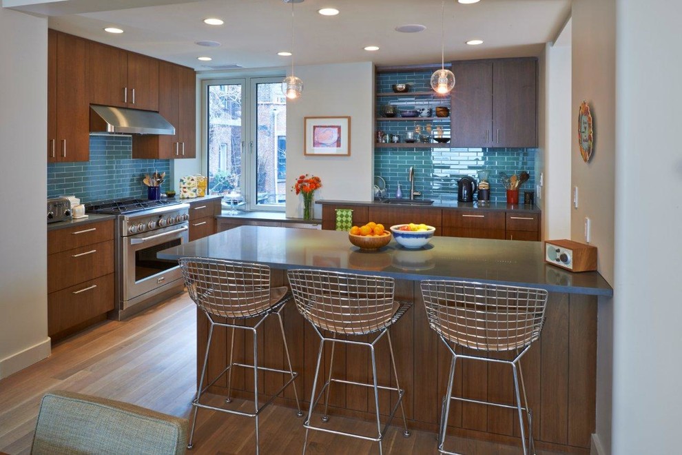 Bild på ett funkis kök och matrum, med släta luckor, rostfria vitvaror, skåp i mörkt trä, blått stänkskydd och stänkskydd i tunnelbanekakel
