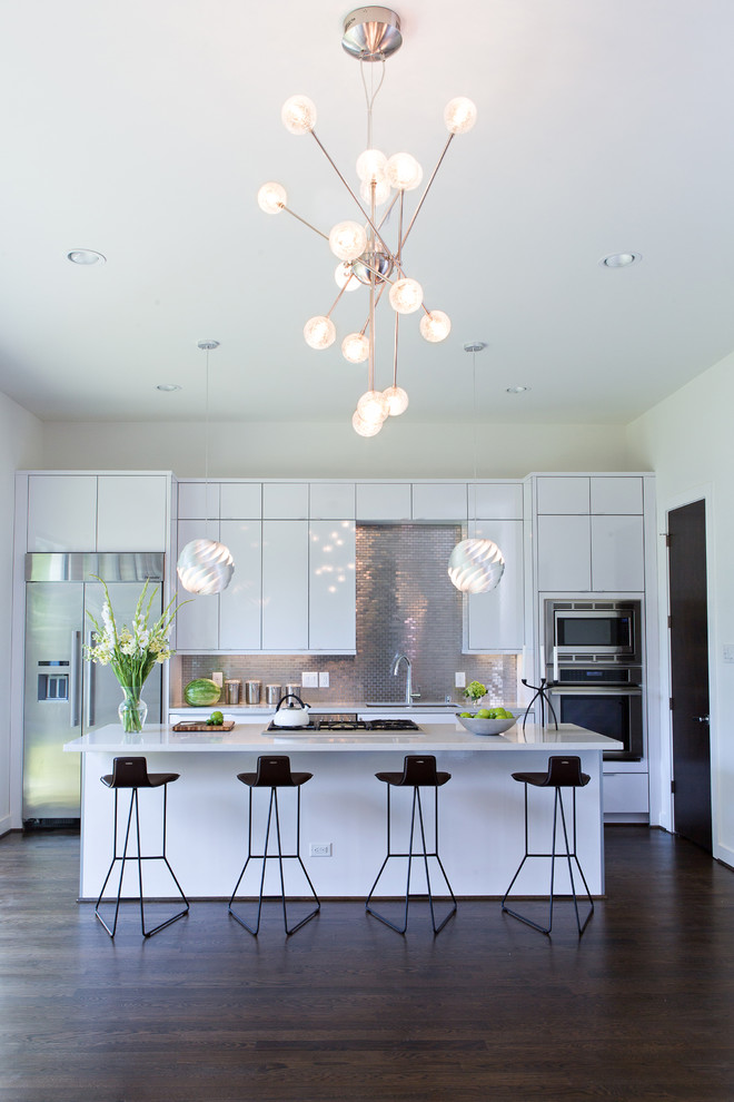 This is an example of a contemporary kitchen in Houston with flat-panel cabinets, white cabinets, metallic splashback, dark hardwood flooring and an island.