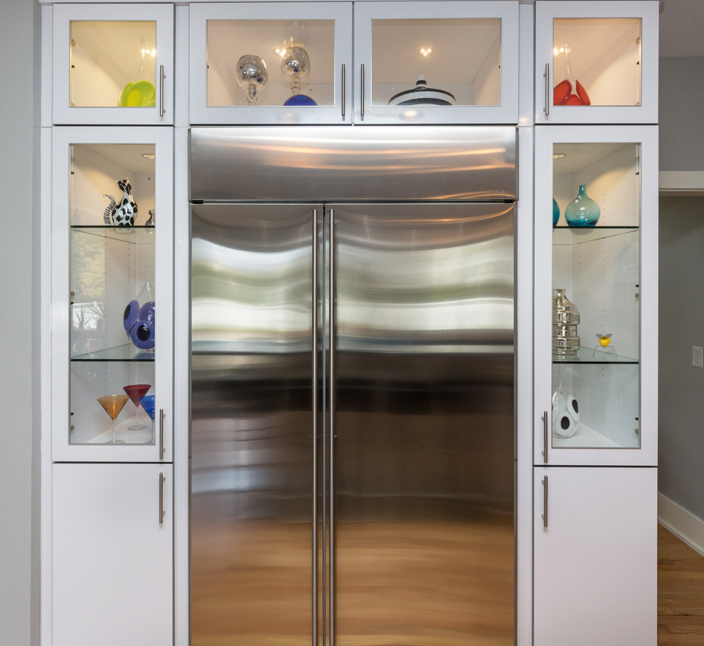Exempel på ett stort modernt kök, med en undermonterad diskho, släta luckor, vita skåp, granitbänkskiva, flerfärgad stänkskydd, stänkskydd i mosaik, rostfria vitvaror, ljust trägolv och en köksö