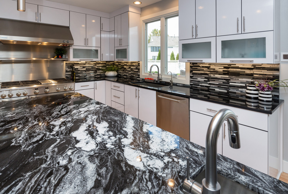 Example of a large trendy u-shaped light wood floor open concept kitchen design in Other with an undermount sink, flat-panel cabinets, white cabinets, granite countertops, multicolored backsplash, mosaic tile backsplash, stainless steel appliances and an island