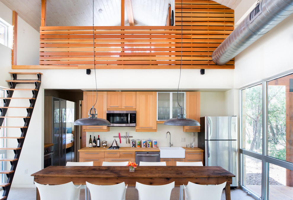 Diseño de cocina comedor lineal contemporánea con fregadero sobremueble, armarios estilo shaker, puertas de armario de madera clara y electrodomésticos de acero inoxidable