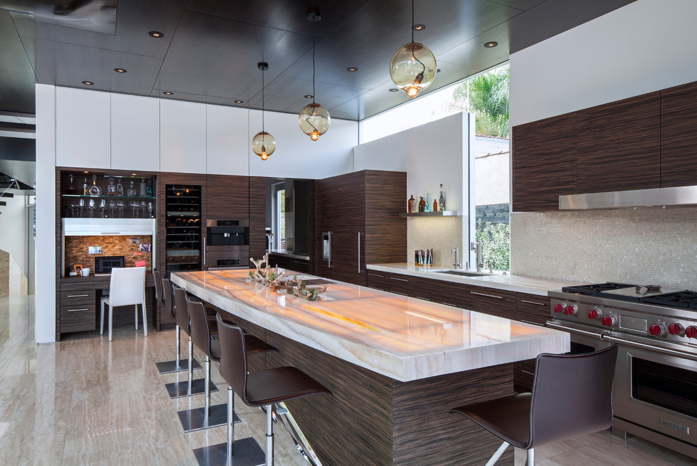 Moderne Küche mit Unterbauwaschbecken, flächenbündigen Schrankfronten, dunklen Holzschränken, Küchenrückwand in Grau, Kücheninsel und Elektrogeräten mit Frontblende in Los Angeles