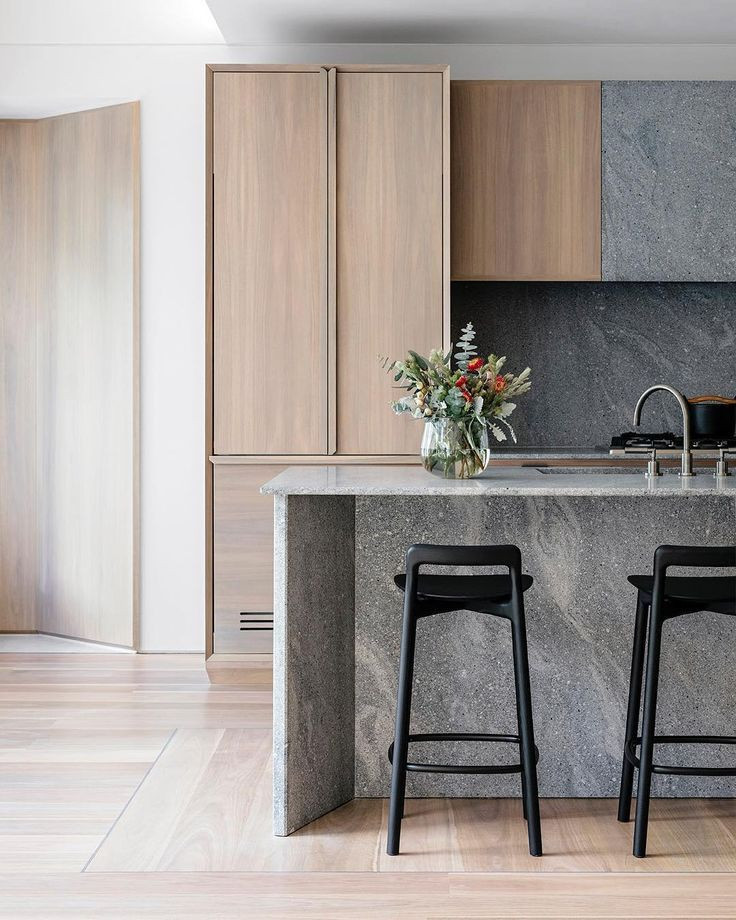 Foto på ett mellanstort funkis grå linjärt kök med öppen planlösning, med en undermonterad diskho, luckor med profilerade fronter, skåp i mellenmörkt trä, bänkskiva i betong, grått stänkskydd, stänkskydd i sten, rostfria vitvaror, ljust trägolv, en köksö och brunt golv