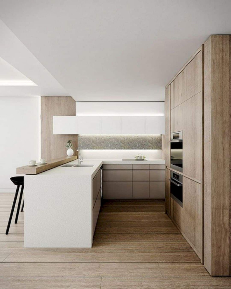 Large contemporary l-shaped open plan kitchen in Columbus with a submerged sink, flat-panel cabinets, light wood cabinets, wood worktops, white splashback, stainless steel appliances, medium hardwood flooring, an island, brown floors and white worktops.