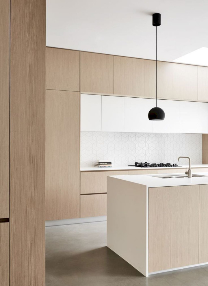 Large contemporary l-shaped open plan kitchen in Columbus with a submerged sink, flat-panel cabinets, light wood cabinets, quartz worktops, white splashback, ceramic splashback, stainless steel appliances, laminate floors, an island, beige floors and white worktops.