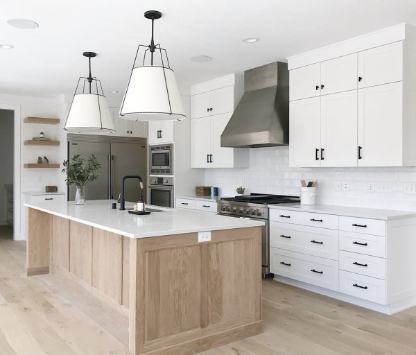 This is an example of a large contemporary l-shaped open plan kitchen in Columbus with a submerged sink, beaded cabinets, white cabinets, quartz worktops, white splashback, metro tiled splashback, stainless steel appliances, light hardwood flooring, an island, brown floors and white worktops.