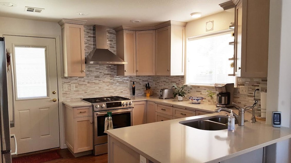 Bild på ett funkis kök, med en dubbel diskho, skåp i shakerstil, skåp i ljust trä, bänkskiva i kvartsit, beige stänkskydd, stänkskydd i mosaik, rostfria vitvaror och mörkt trägolv
