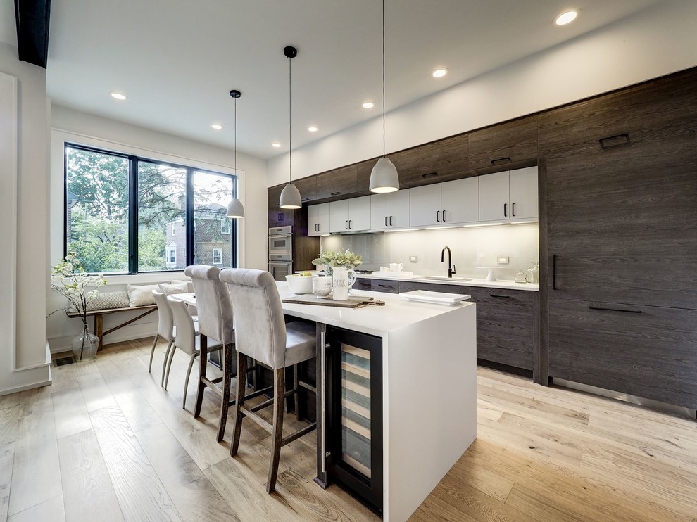 Design ideas for a contemporary l-shaped kitchen in DC Metro with a submerged sink, engineered stone countertops, white splashback, glass tiled splashback, stainless steel appliances, an island and white worktops.