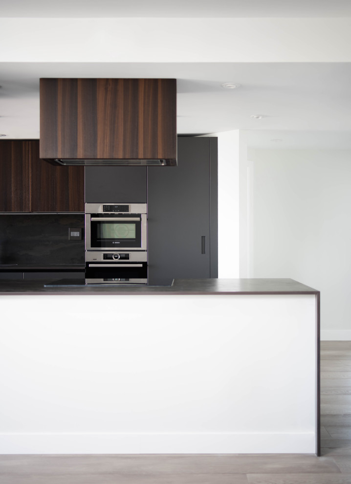 Aménagement d'une grande cuisine contemporaine en bois brun avec un placard à porte plane, parquet clair et un sol gris.
