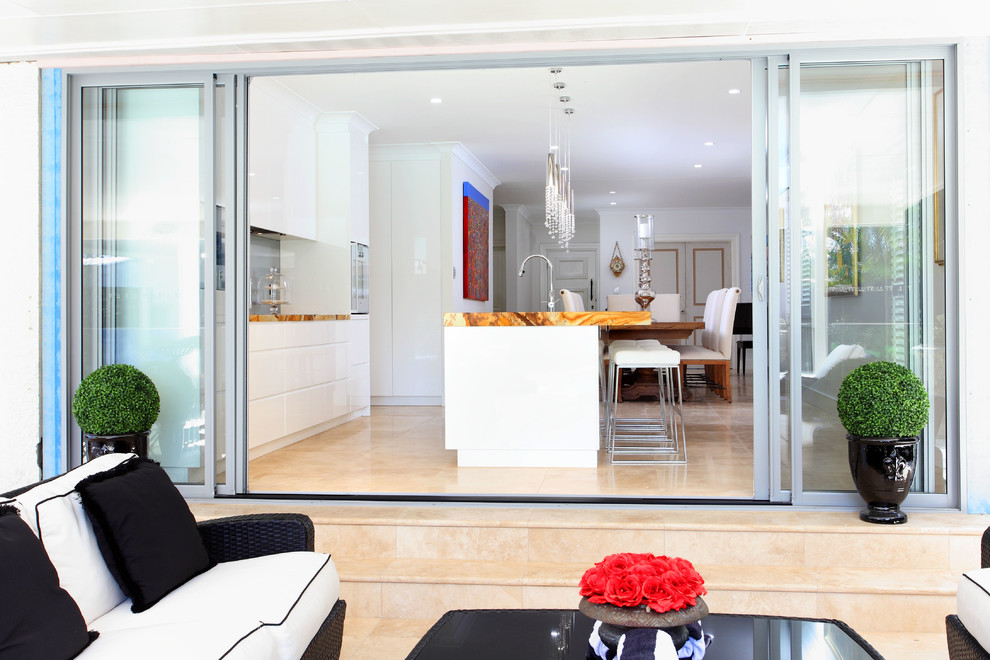 This is an example of a contemporary kitchen/diner in Brisbane with flat-panel cabinets, white cabinets and grey splashback.