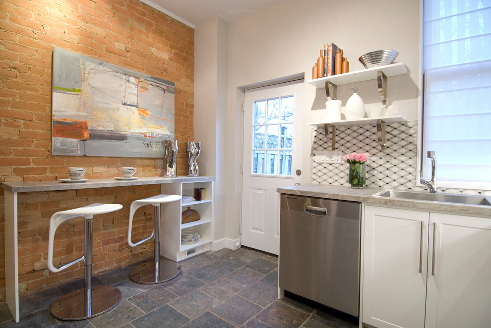 Idée de décoration pour une cuisine design avec un évier 1 bac, un placard à porte shaker, des portes de placard blanches, une crédence grise et un électroménager en acier inoxydable.