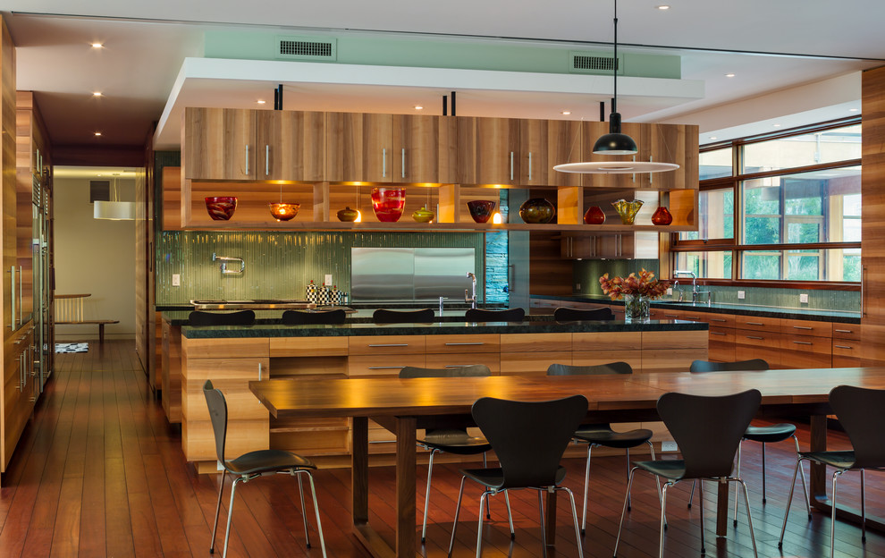 Photo of an expansive contemporary l-shaped kitchen/diner in DC Metro with green splashback, matchstick tiled splashback, a double-bowl sink, medium wood cabinets, stainless steel appliances, medium hardwood flooring and multiple islands.