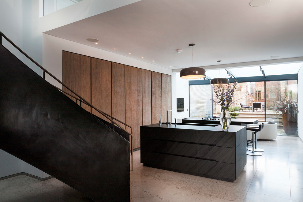 Photo of a large contemporary galley open plan kitchen in London with an integrated sink, flat-panel cabinets, light wood cabinets, quartz worktops, limestone flooring, multiple islands and integrated appliances.