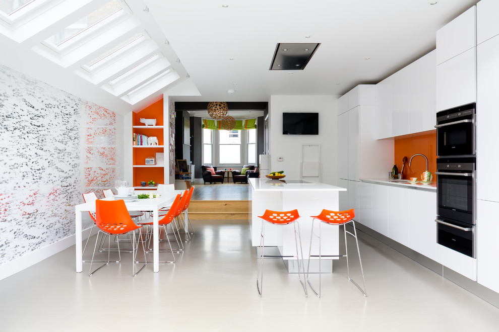 ロンドンにあるコンテンポラリースタイルのおしゃれなキッチン (フラットパネル扉のキャビネット、白いキャビネット、オレンジのキッチンパネル、ガラス板のキッチンパネル、黒い調理設備) の写真