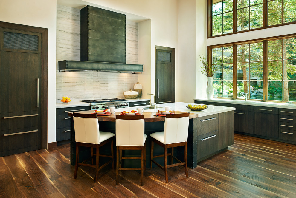 Example of a trendy l-shaped open concept kitchen design in Denver with flat-panel cabinets, dark wood cabinets, stainless steel appliances and an island