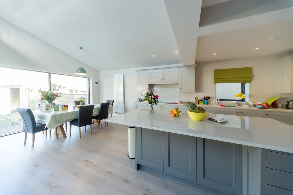 Idées déco pour une cuisine ouverte classique avec un placard à porte shaker, des portes de placard grises, parquet clair et îlot.