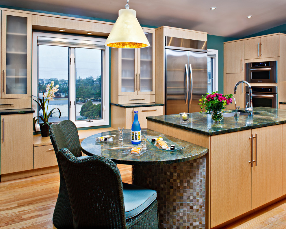 Photo of a medium sized contemporary kitchen in New York with a submerged sink, flat-panel cabinets, light wood cabinets, granite worktops, multi-coloured splashback, stainless steel appliances, medium hardwood flooring and an island.