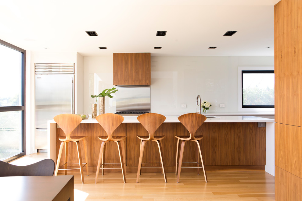 Moderne Küche mit Unterbauwaschbecken, hellbraunen Holzschränken, Küchenrückwand in Metallic, Küchengeräten aus Edelstahl, hellem Holzboden, Kücheninsel und beigem Boden in Toronto