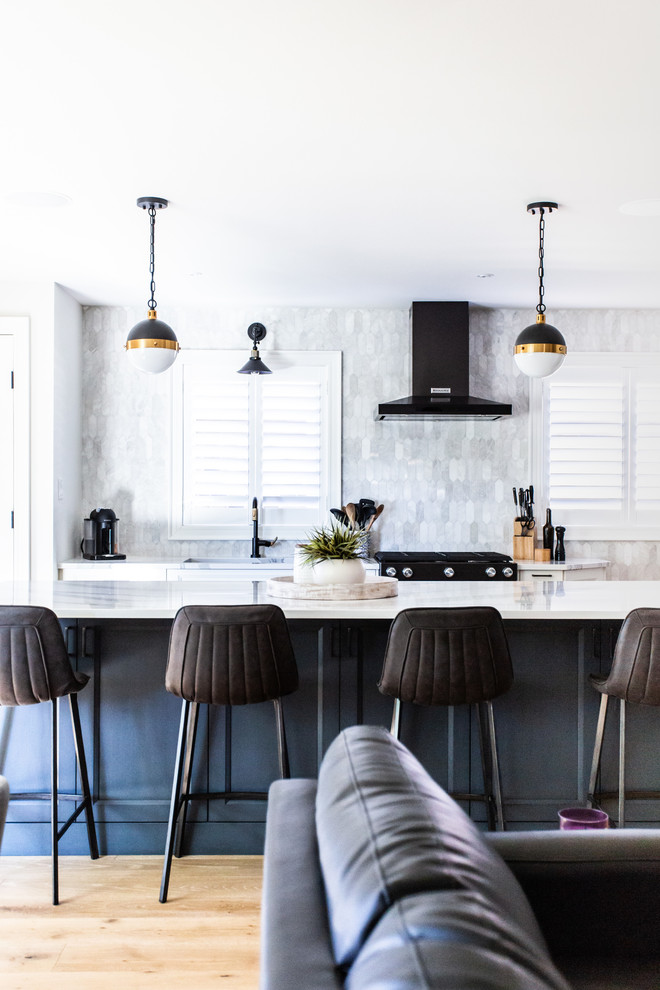 Exempel på ett mellanstort modernt vit vitt kök, med skåp i shakerstil, blå skåp, bänkskiva i kvartsit, vitt stänkskydd, stänkskydd i marmor, svarta vitvaror, en undermonterad diskho, ljust trägolv, en köksö och beiget golv