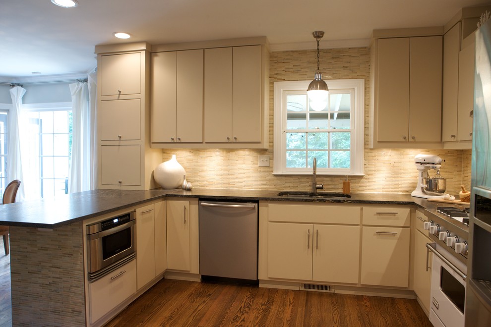 Moderne Küche mit weißen Elektrogeräten, flächenbündigen Schrankfronten, beigen Schränken, Küchenrückwand in Beige, Rückwand aus Stäbchenfliesen und Unterbauwaschbecken in Raleigh