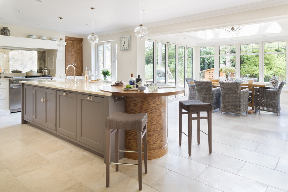 Eat-in kitchen - mid-sized contemporary limestone floor eat-in kitchen idea in London with a double-bowl sink, recessed-panel cabinets, metallic backsplash, mirror backsplash, stainless steel appliances and an island