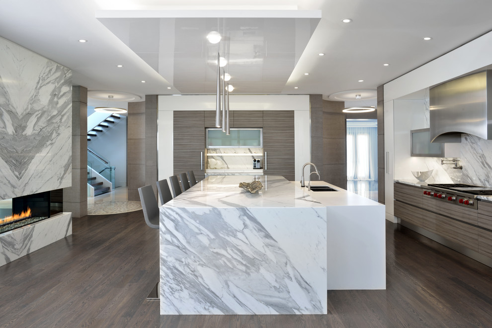 This is an example of a contemporary kitchen in Toronto with a double-bowl sink, marble worktops, white splashback, marble splashback, stainless steel appliances, dark hardwood flooring, multiple islands and brown floors.