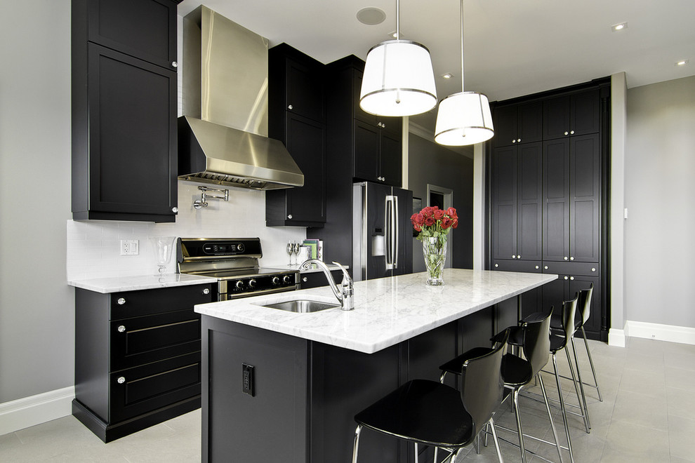 Esempio di una cucina parallela minimal con top in marmo, elettrodomestici in acciaio inossidabile, lavello sottopiano, ante con riquadro incassato e paraspruzzi bianco