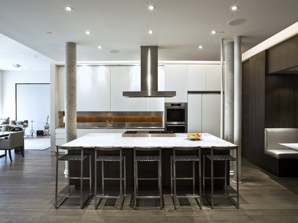 Trendy galley open concept kitchen photo in New York with flat-panel cabinets, white cabinets, metallic backsplash and paneled appliances